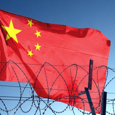 Chinese flag behind barbed wire